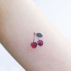 two cherries on the back of a woman's arm