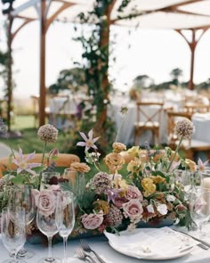 the table is set with flowers and wine glasses