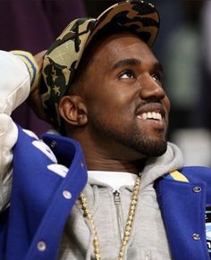 a man wearing a blue jacket and camo hat with his hands on his head