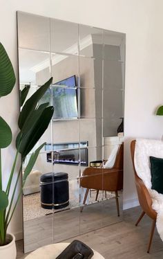 a living room with a large mirror on the wall and a chair in front of it