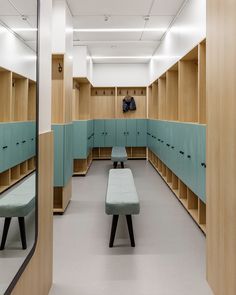 an empty locker room with benches and mirrors