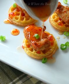 waffles with sauce being drizzled over them on a white plate