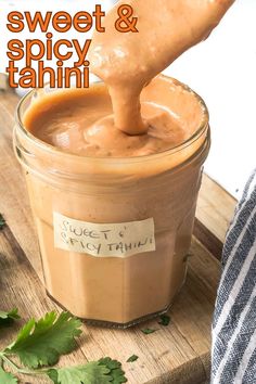 a spoon full of sweet and spicy tahitii sauce on a wooden cutting board