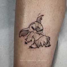 a tattoo on the leg of a person with a small rabbit in it's lap