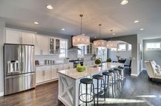 a large kitchen with an island in the middle and lots of stools around it