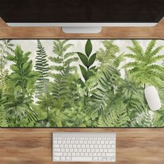 a computer desk with a keyboard and mouse on it, surrounded by green plants in front of a monitor