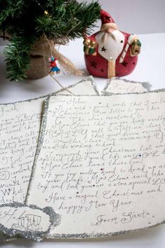 an old letter is sitting next to a christmas tree and a small ornament