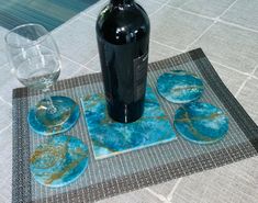 a bottle of wine and coasters on a table