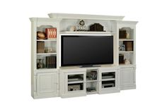 a white entertainment center with bookshelves and a flat screen tv mounted on the wall