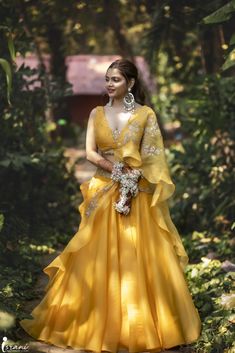 a woman in a yellow dress is posing for the camera