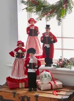 christmas figurines are displayed in front of a window