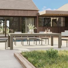 an outdoor dining table and chairs in front of a house with a swimming pool area