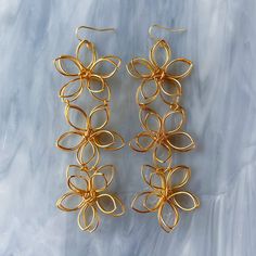 As seen on NETFLIX! On both season 5 and 6 of Love is Blind! The Moselle earrings feature three unique wire golden flowers, arranged in a row to create a bold and eye-catching design. Designed with comfort in mind, these earrings are lightweight and easy to wear, with a secure and comfortable fit that will stay in place all day long. Whether you're walking down the aisle, taking photos, or dancing the night away, these earrings are sure to make you feel confident, radiant, and truly unforgettabl Gold Flower Earrings, Wire Jewelry Patterns, Love Is Blind, Flower Outline, Wire Flowers, Jewelry Design Inspiration, Golden Flower, Hand Craft, Earrings Dainty