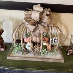 a decorative pumpkin sitting on top of a table next to candles and other decor items