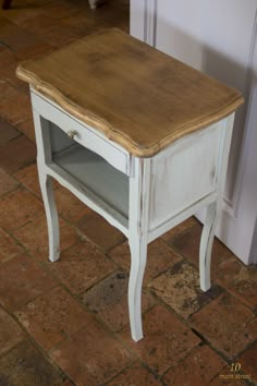 a small white table with a drawer on top