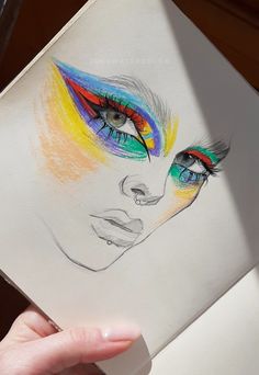 a drawing of a woman's face with bright colored eyeliners on it