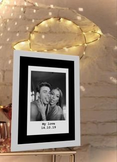 a photo frame hanging on a shelf with lights around it