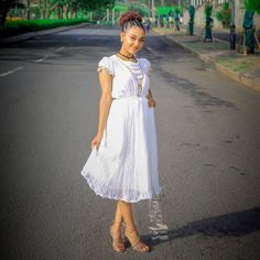 This exquisite Habesha dress is a true masterpiece of Ethiopian fashion. The dress is made from the finest handwoven Menen fabric, which is known for its softness, durability, and luxurious feel. The fabric is carefully crafted by skilled artisans using traditional weaving techniques that have been passed down through generations. The dress is a beautiful shade of white, which adds to its timeless elegance and sophistication. The simple yet stunning design of the dress allows the beauty of the f Ethiopian Fashion, Eritrean Dress, Habesha Dress, Habesha Kemis, Traditional Weaving, Shades Of White, Weaving Techniques, Timeless Elegance, The Beauty