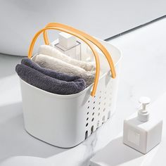 a white basket filled with towels next to a soap dispenser on a counter