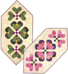 two quilted hexagons with hearts on them, one in pink and the other in green