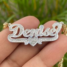 Make a statement with this personalized cursive double name plate pendant! Give your jewelry box an upgrade with this classy, diamond cut beauty - featuring your name and an adorable heart underline with an added genuine diamond accent! So sweet it'll give you heart eyes! The genuine diamond is set above the dot of a lowercase "i" or "j". If your name does not have an "i" or "j", we can set the diamond in the center of the heart. Choose from 10k or 14k yellow, rose, or white gold. Metal: 10k or West Indian Bangles, Double Name, Picture Pendant, Bangles Indian, The Dot, Name Jewelry, Heart Eyes, Kids Jewelry, So Sweet