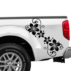 a white truck with black flowers painted on it's tailgate and tire rims