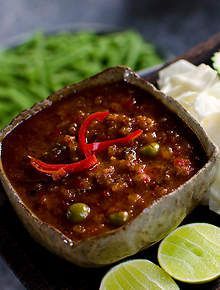 a wooden tray topped with lots of food next to lettuce and limes