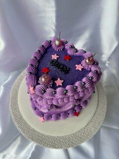 a heart shaped purple cake with stars on it