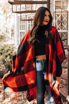 Our gorgeous 'Caramel Kisses' poncho is so easy to drape on and go with its lightweight material, large red and black buffalo check pattern, fringed trim detailing, open sides, and ultra draped silhouette that cascades into a straight mid-thigh length hemline! Casual Red Cape For Fall, Casual Red Cape For Autumn, Red Folk Style Poncho For Fall, Red Shawl Cape For Fall, Oversized Red Cape For Fall, Fall Red Shawl Cape, Red Bohemian Poncho With Fringe, Oversized Plaid Poncho For Fall, Red Bohemian Poncho Cape