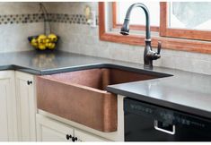 a kitchen sink with an apron style copper finish