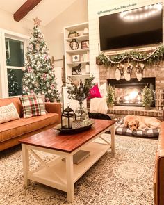 a living room decorated for christmas with a dog sleeping on the coffee table