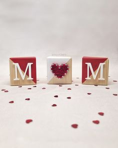 two wooden blocks with the letter m on them and a red heart in the middle