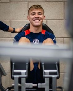 a man sitting in a chair smiling at the camera