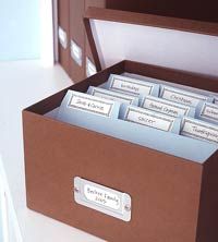 a brown box filled with lots of cards on top of a white counter next to a window