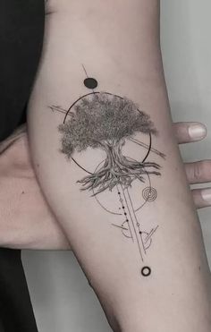 a woman's arm with a tree on it and an arrow in the middle