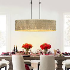 a dining room table set for four with flowers in vases and plates on it