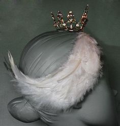 a white feather hat with a gold crown on top