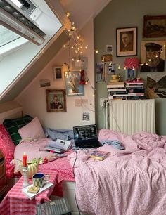 a bedroom with a laptop on the bed and many pictures hanging up in the wall