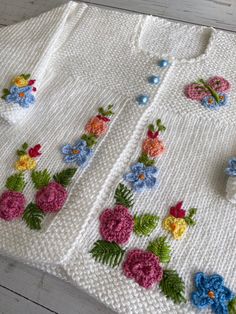 a crocheted sweater with flowers and butterflies on it