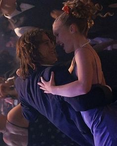 two people hugging each other in front of a crowd