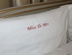 a white pillow with the words miss to mrs on it and a red embroidered pillow case