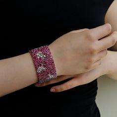 This Enchanted Evening Hyperion Bracelet by Ruchi New York is a masterpiece that is sure to turn heads. The mixed shape rubies in an exotic pattern, interspaced with diamond baguettes, make a bold statement when worn. The striking combination of rubies and diamonds results in a piece that exudes luxury and sophistication. Featuring 65.97 carats of rubies and 7.40 carats of diamonds, this bracelet is truly a work of art. The bracelet is 7 inches in length and has a bar clasp closure, made of 18k Hand Set Ruby Bracelets For Party, Party Bracelets With Hand Set Rubies, Hand-set Ruby Bracelets For Parties, Rubies And Diamonds, Colorful Gemstones, Enchanted Evening, Ruby Diamond, Baguette Diamond, High Jewelry