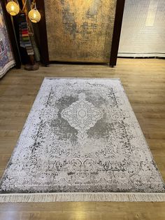 a large area rug is on the floor in front of a wall with two lamps