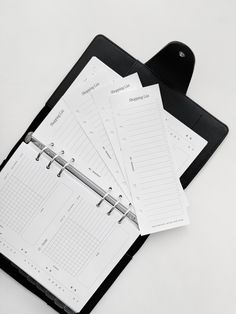 a black binder with three calendars and a clipboard on the top one