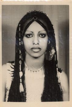 an old black and white photo of a woman with long braids on her head