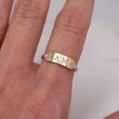 a woman's hand with a gold ring that says ama