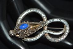 Vintage or already antique silver brooch dates back to the 20s of the last century. Made in the form of a dragon, the head is carved and decorated with lapis lazuli. The head is raised and not soldered to the body of the dragon. A unique example of oriental culture. There is a small chip on the back of the brooch. Year: 1920-s Signed: 925 The brooch is in very good vintage condition. Please look very carefully at the photos before buying this thing. I try to take photos as close as possible and show products from all sides. This unique piece will fill in any wardrobe. If you have any questions, please do not hesitate to contact me. Thank you for stopping by! Vintage Carved Brooches For Gifts, Vintage Carved Brooches Gift, Victorian Antique Silver Brooch For Gift, Victorian Antique Silver Brooches As Gift, Ornate Antique Silver Brooch As Gift, Ornate Antique Silver Brooch For Gift, Silver Art Nouveau Brooches For Gifts, Silver Art Nouveau Brooches As Gift, Victorian Antique Silver Brooch