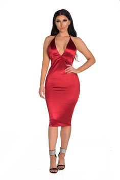 a woman in a red dress posing with her hands on her hips and wearing high heels