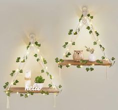 two shelves decorated with plants and lights in the shape of triangle shaped triangles, each shelf has an owl on it