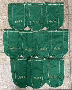 six green bags sitting on top of a tile floor